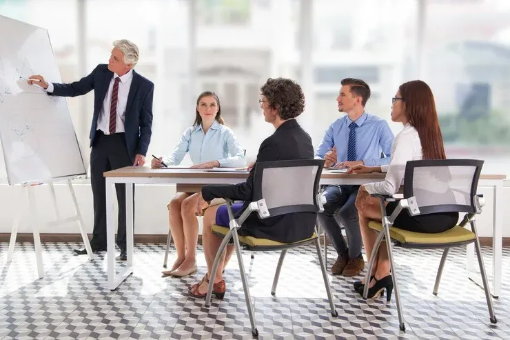 Trainer at a flip chart teaching a group of seated employees
