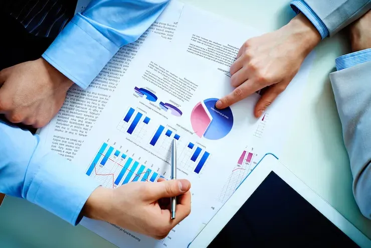 Business people reviewing printed reports with bar and pie charts
